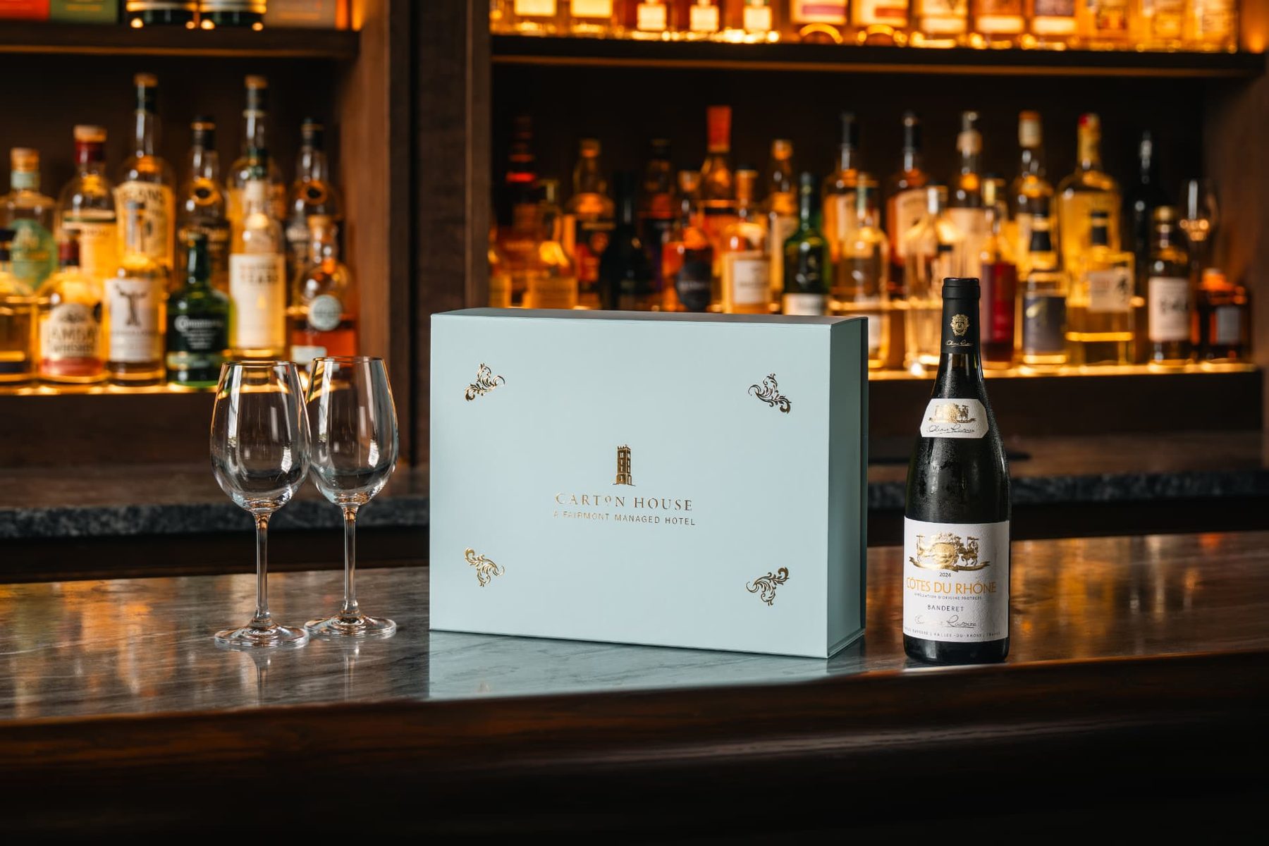 Landscape rigid gift box in duck egg blue with gold foil logo and four decorative gold foil crests on the lid.