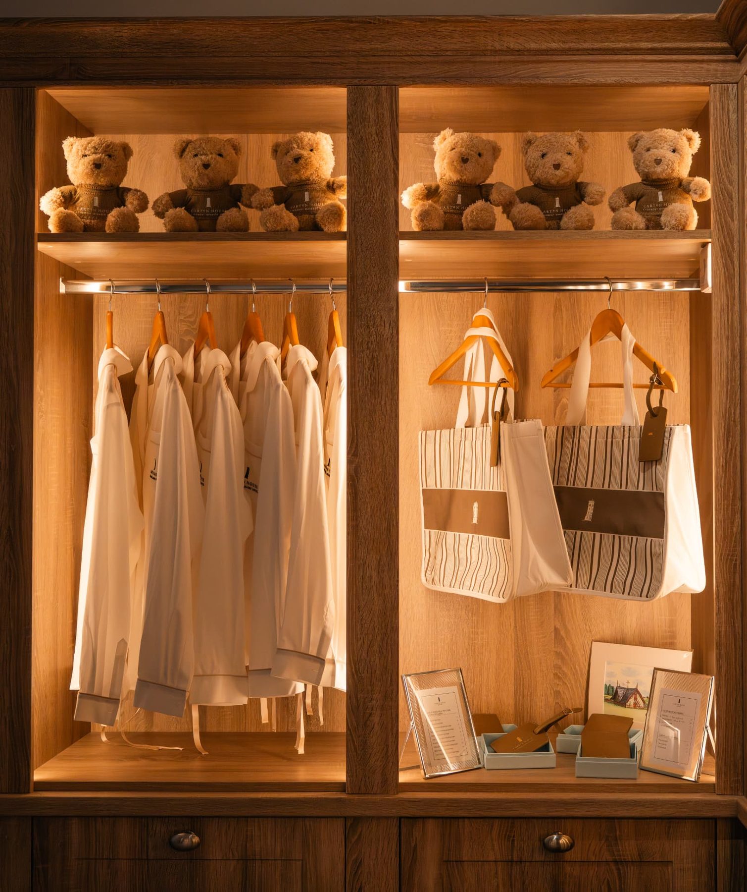 Two off white and brown striped cotton tote bags, with brown cotton handles, an exterior brown fabric panel and a white embroidered logo.