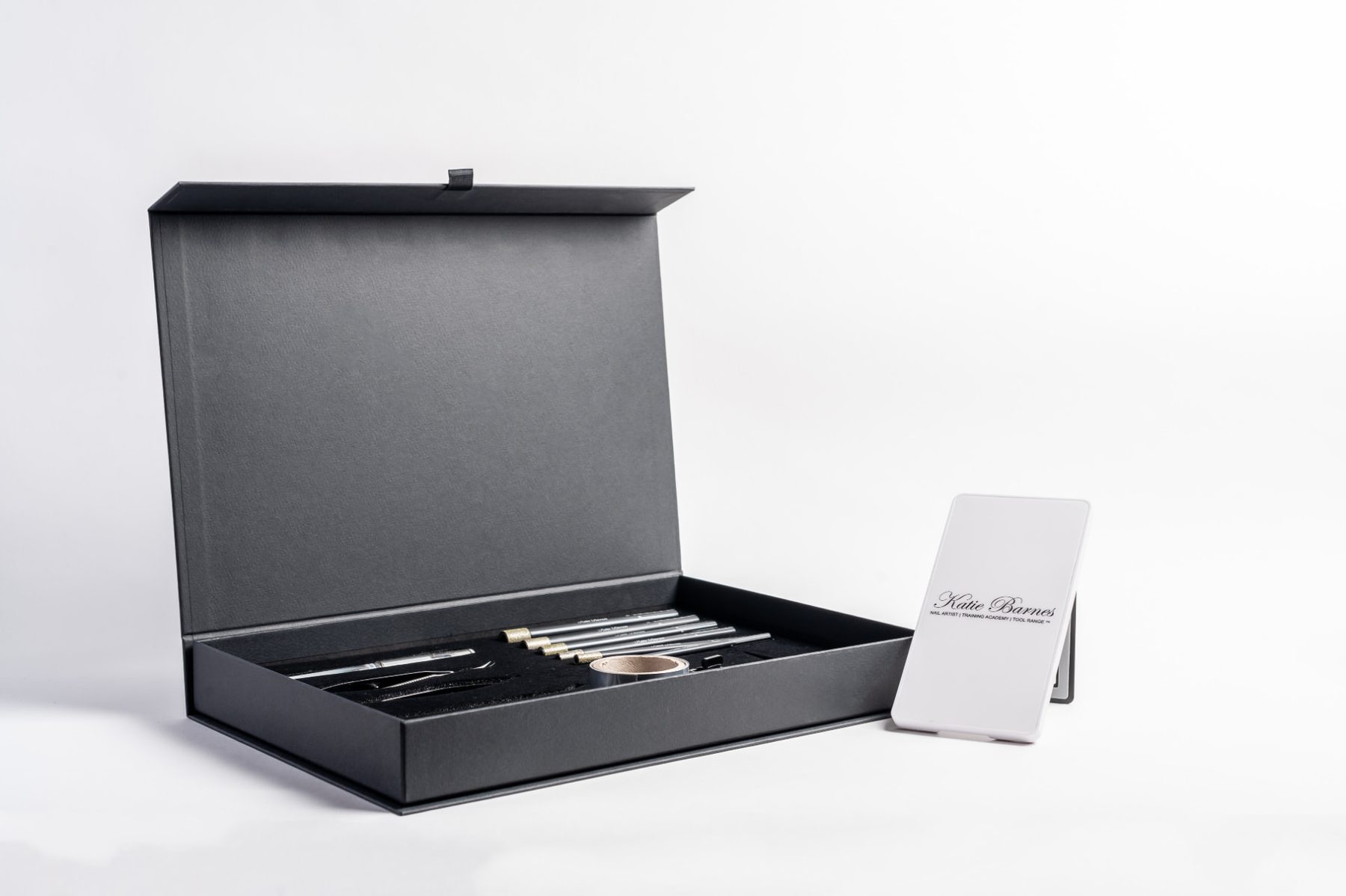 Matt black rigid presentation box with magnetic flap closure, containing a custom black foam insert. Designed for tool storage.