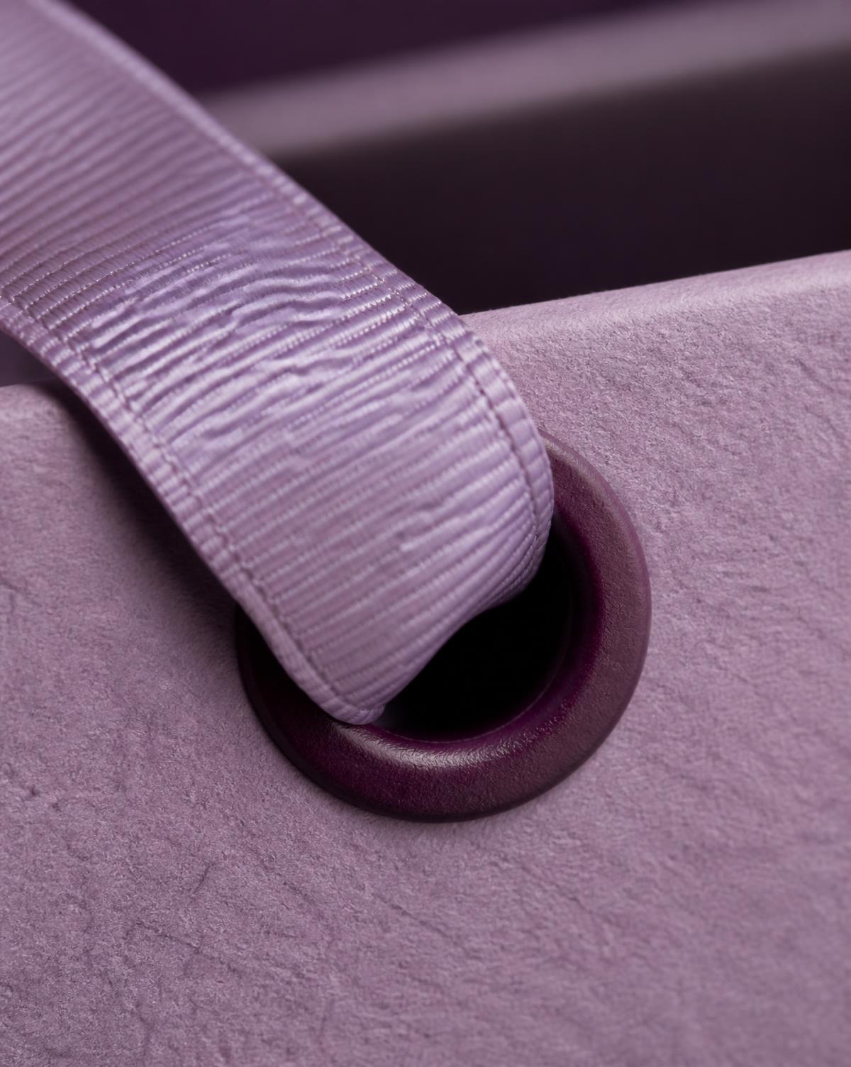 Macro detail of a grosgrain ribbon handle through a reinforced eyelet